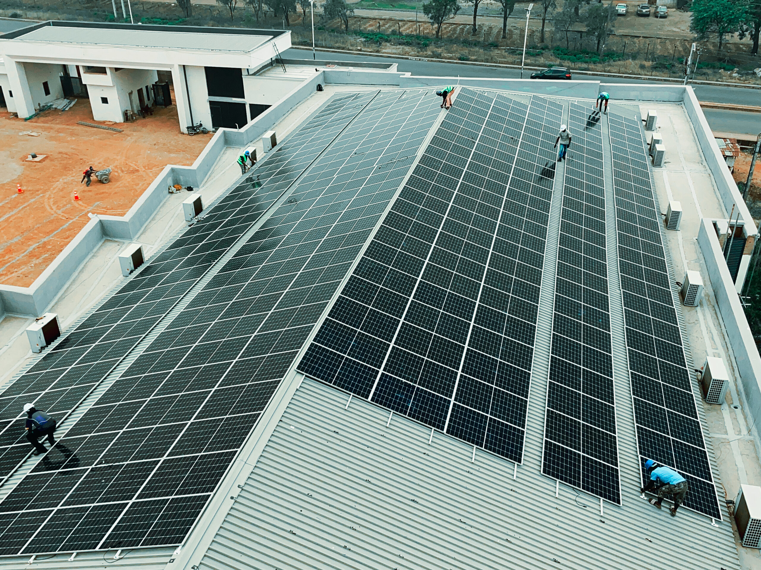 Technicians installing solar panels on a commercial building
